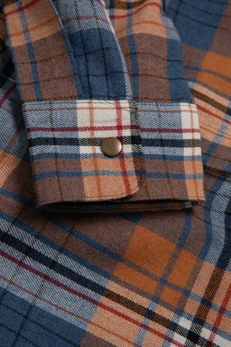 Close-up of the cuff of fall men's snap front plaid western flannel shirt