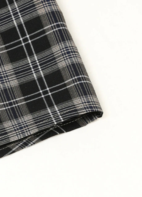 Detail of shirttail hemline on kids black plaid short sleeve shirt