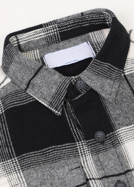 Detail of spread collar on kids black white plaid flannel shirt