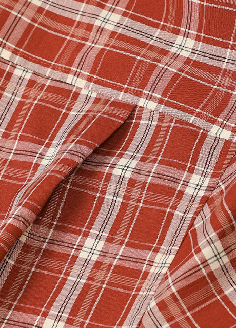 Close-up of the back pleats of rust red men's button front plaid short sleeve shirt