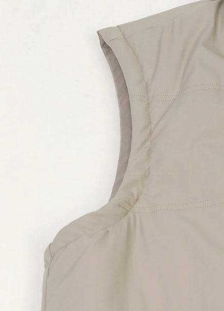 Close-up of the shoulder edge of light gray men's lightweight puffer vest with flannel lining