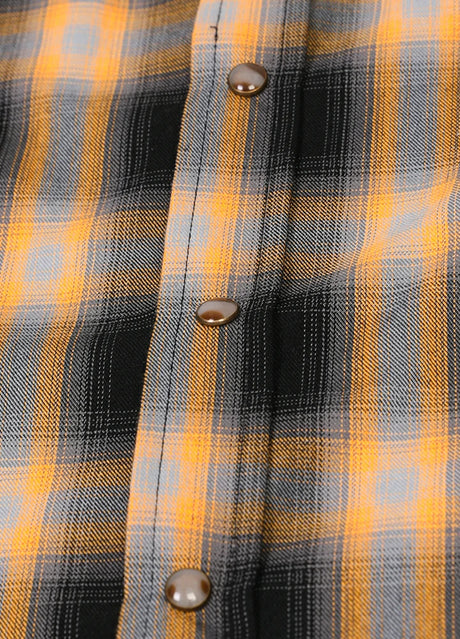 Close-up of the snap button of orange men's western plaid vest