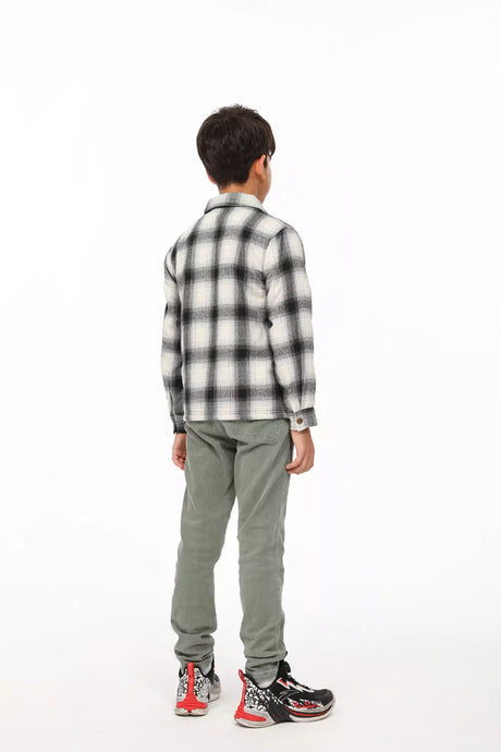 A boy in midnight snowfall flannel shacket with his back to the camera