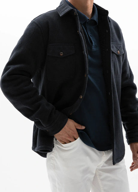 A man with one hand in the pocket in a twill black men's seam pocket winter fleece shirt jacket