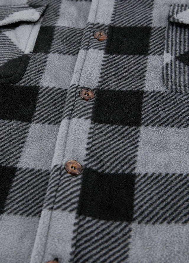 Close-up of the button of grey men's seam pockets sherpa lined shirt jacket