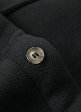 Close-up of the button of solid black men's seam pockets sherpa lined shirt jacket