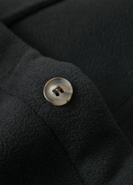 Close-up of the button of solid black men's seam pockets sherpa lined shirt jacket