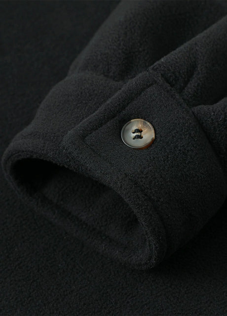 Close-up of the cuff of solid black white men's sherpa lined shirt jacket with button closure