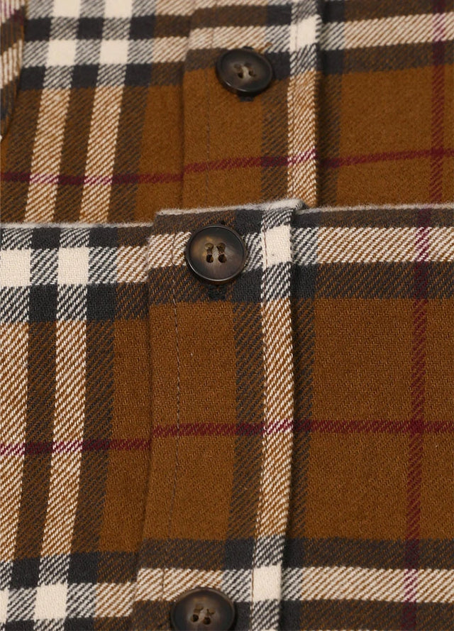 Close-up of the button of brown midweight flannel shirt for men