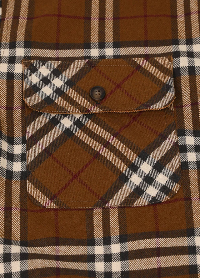 Close-up of the pocket of brown men's midweight plaid flannel shirt