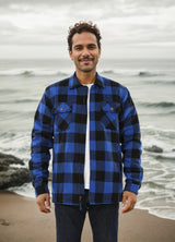 A man standing on the beach in a buffalo blue men's fleece lined flannel shirt jacket 