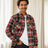 A man with one hand in pocket in a rust red men's fleece lined flannel shirt jacket