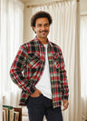 A man with one hand in pocket in a rust red men's fleece lined flannel shirt jacket