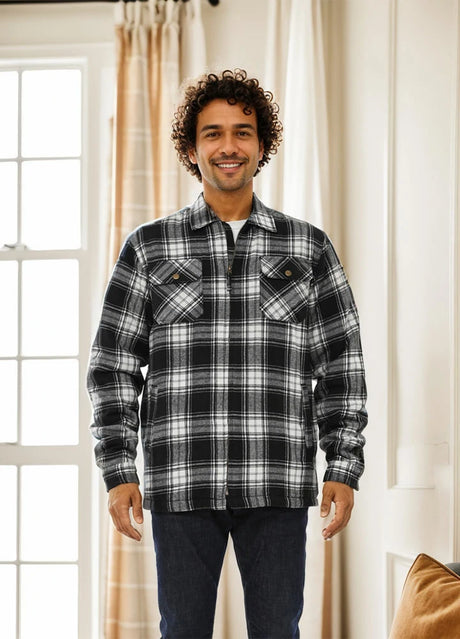 A man stands in front of the curtains in a black white men's fleece lined flannel shirt jacket